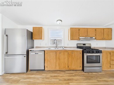 Kitchen with a sink, light countertops, appliances