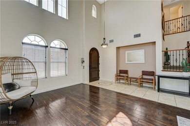 Foyer entrance with a high ceiling and light wood-
