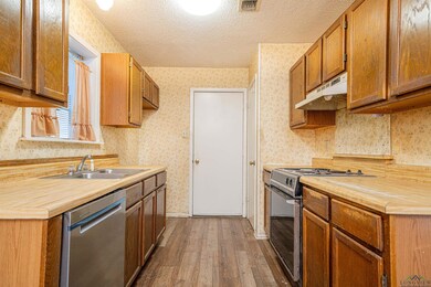 Kitchen with sink, a textured ceiling, stainless s