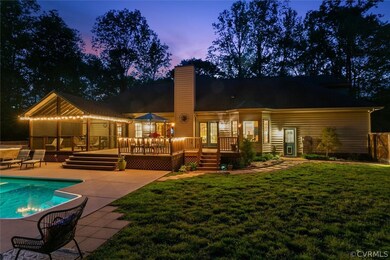 Back house at dusk with a yard, a pool side deck, and a patio