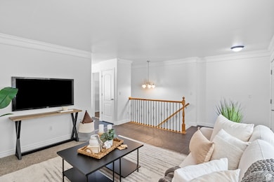 View 2 of Living room featuring ornamental molding and a chandelier with downstairs entrance.