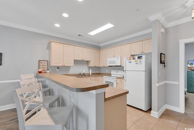 Kitchen featuring kitchen peninsula, white applian