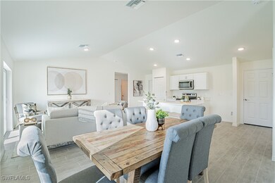 Dining space with vaulted ceiling, visible vents,