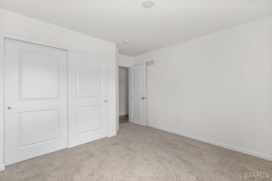 Unfurnished bedroom featuring light colored carpet and a closet