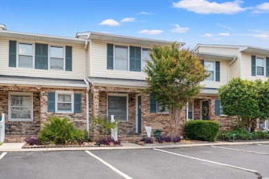 Multi unit property featuring uncovered parking and brick siding