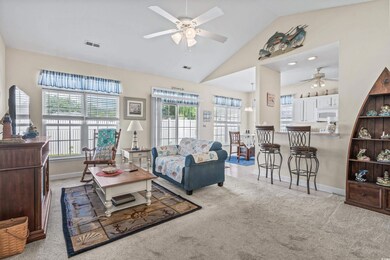 Carpeted living room featuring ceiling fan, a weal