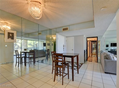 Dining room with a notable chandelier, light tile