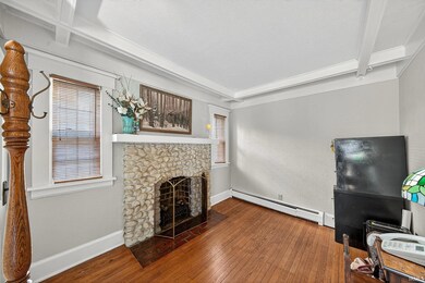 Hearth Room with beamed ceiling, hardwood / wood-style floors, a fireplace, and a textured ceiling