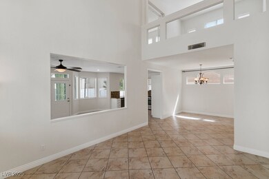 Unfurnished room with light tile patterned floors, a chandelier, ceiling fan, and a towering ceiling