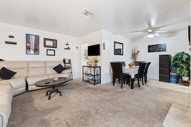 Living area featuring visible vents, carpet floori