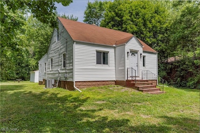View of front of house featuring a front yard and a shingled roof