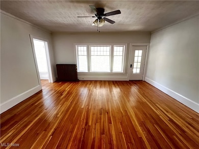 Unfurnished room with ceiling fan, a textured ceiling, crown molding, and wood-type flooring