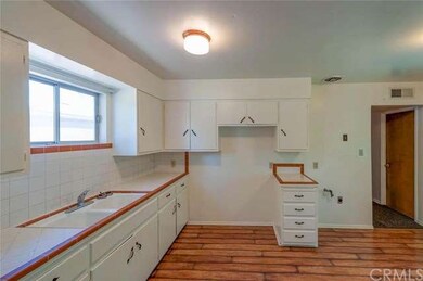 Kitchen with laminate flooring and tiled counters.