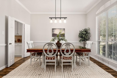 Dining room with crown molding and wood-type flooring