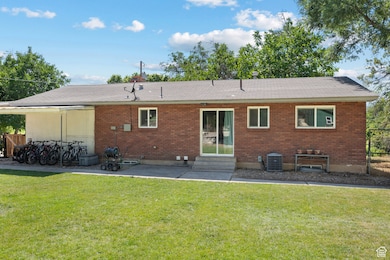 Rear view of house featuring entry steps, brick siding, and a patio area
