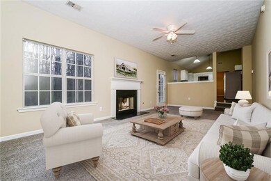 Carpeted living room featuring a fireplace with fl