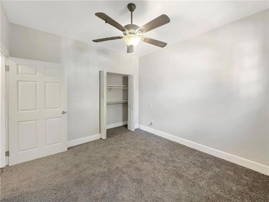 Unfurnished bedroom featuring carpet, ceiling fan,