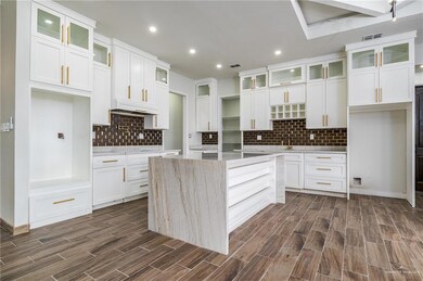Kitchen with a center island, tasteful backsplash, and white cabinets