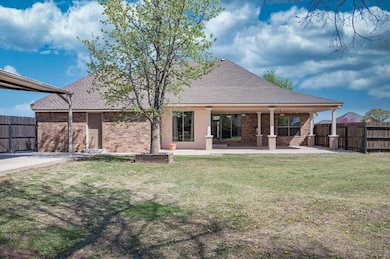 Back of property with brick siding, fence, a patio