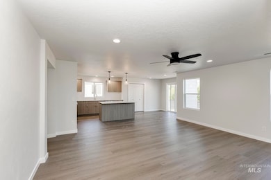 Unfurnished living room with light wood-style floors, a textured ceiling, a ceiling fan, and recessed lighting