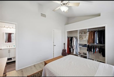 Spacious upstairs bedroom with vaulted ceiling, walk-in closet, and direct access to private en-suite bathroom.