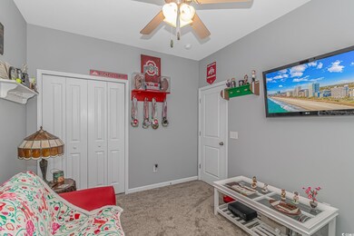 Carpeted bedroom featuring ceiling fan and a close