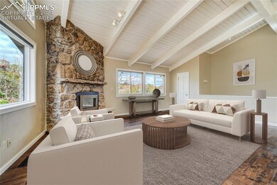 Living room with beamed ceiling, hardwood flooring
