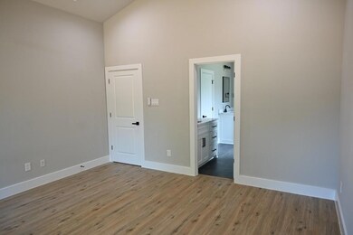 Unfurnished room with a towering ceiling, light hardwood / wood-style flooring, and sink