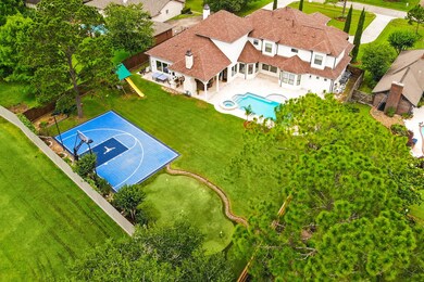 The resort-like outdoor oasis offers a large lawn separating the sports court and putting green from the pool area, covered patio and home.