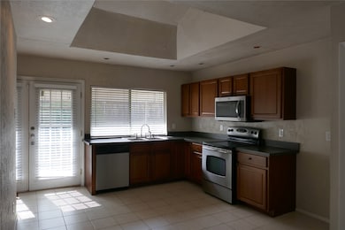 Stainless appliances, sunny window and french doors to patio and side yard.