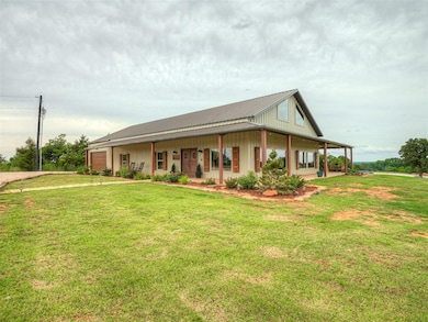Farmhouse featuring a front yard, a metal roof, and board and batten siding
