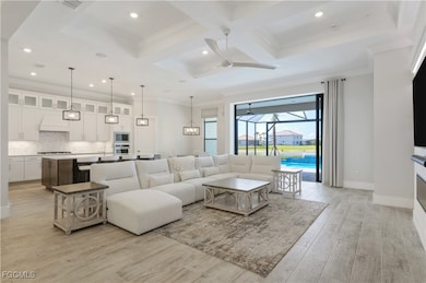 Living area featuring a ceiling fan, coffered ceil