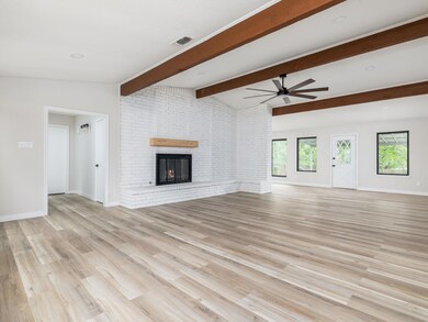 Unfurnished living room featuring ceiling fan, li