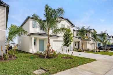 Traditional home with concrete driveway, a front yard, a garage, and covered porch