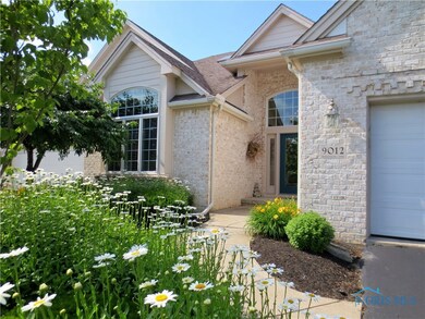 A flower-lined walkway leads you to the front entr
