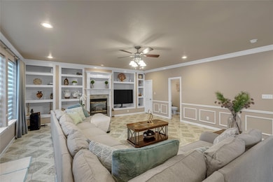Living room featuring ceiling fan, a decorative wa