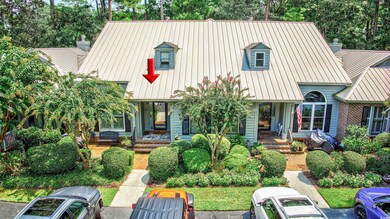 View of front of home with a metal roof, a chimney, a standing seam roof, and a porch