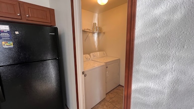 Laundry room with separate washer and dryer and light tile patterned floors