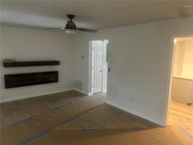 Unfurnished living room featuring visible vents, b