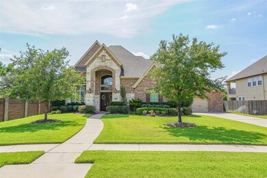 Great curb appeal with a stone and brick exterior and lush landscaping.