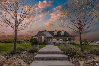 View of front of property with a porch, a lawn, and brick siding