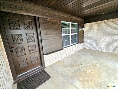 Doorway to property featuring brick siding