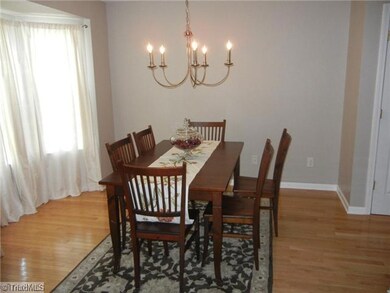 Dining Room. Formal dining room has hardwood floors and bay window and a pretty chandelier