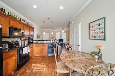 Well-equipped kitchen with ample cabinetry, granite countertops, and breakfast bar seating. (Unit 203)