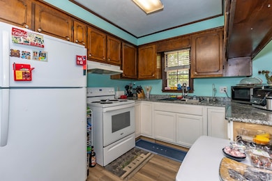 Kitchen with wood finished floors, white appliance