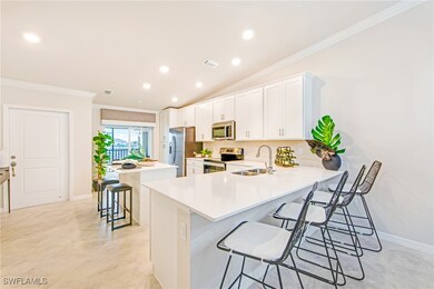 Kitchen with visible vents, a kitchen island, a sink, stainless steel appliances, and a breakfast bar area