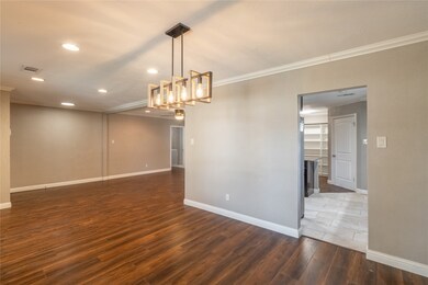 Elegant light fixtures and easy access to the kitchen make this dining area both functional and stylish.