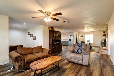 Living room featuring ceiling fan and dark hardwoo