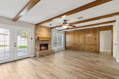 This view of the living room highlights the expansive energy-efficient double-pane windows and the rich wood paneling along the far wall, adding warmth and character to the room.