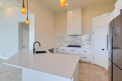 Kitchen featuring white cabinets, a peninsula, ta